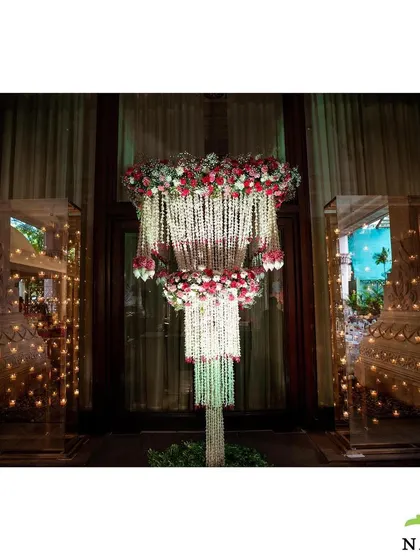 A stunning floral chandelier I created as a centerpiece for an event entrance. This intricate arrangement of jasmine and roses, surrounded by candle-lit displays, adds a touch of romantic luxury.