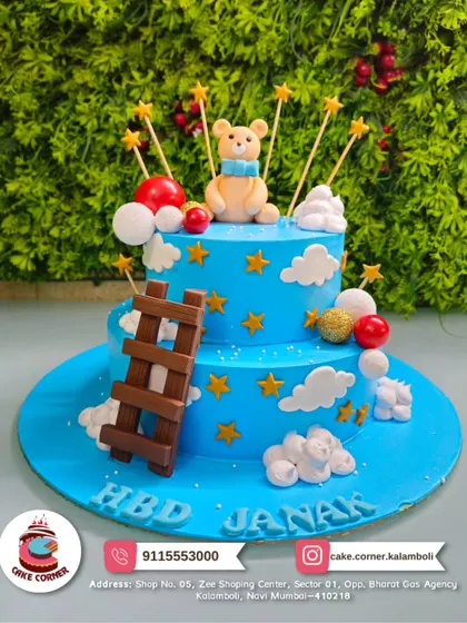 A dreamy two-tier teddy bear cake, reaching for the stars. The cute bear, ladder, and clouds create a whimsical scene for Janak's birthday.