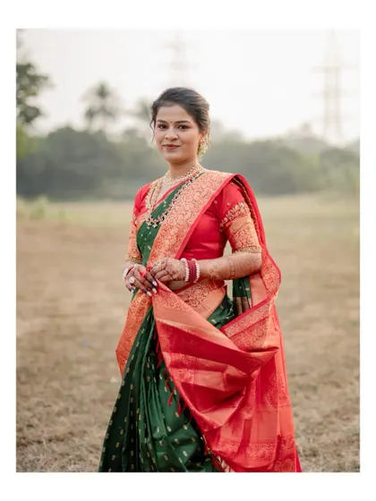A beautiful full-length portrait of the bride-to-be in her stunning green and red traditional saree during her engagement shoot.
