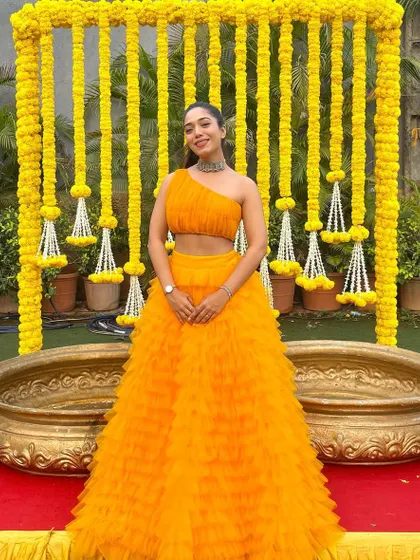 "Don't stress, just wear a yellow dress." Posing against a beautiful marigold backdrop, this outfit is perfect for a traditional Haldi ceremony.