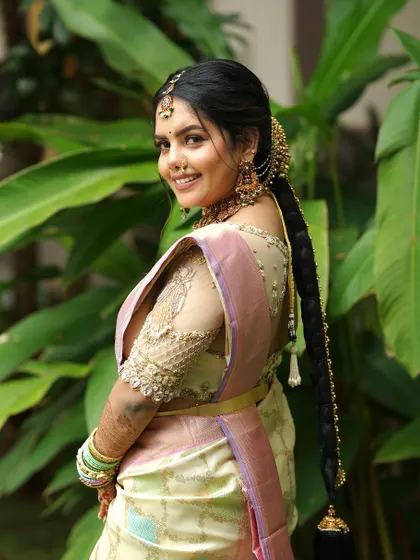 A view from the back, showing the bride's beautiful hairstyle and the keyhole back design of her embroidered blouse.