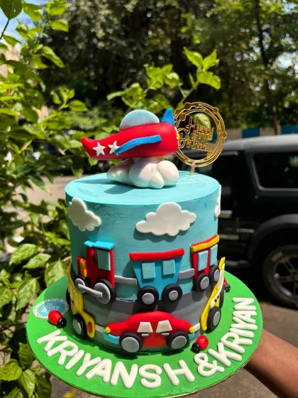 A transportation-themed cake for a twins' birthday. This design features cars, trains, and an airplane, making it perfect for little ones who love all things that go.