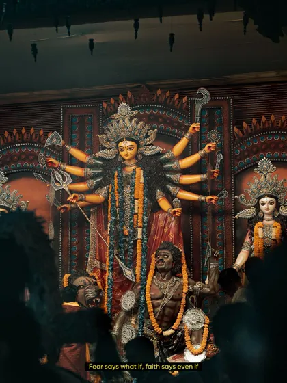 A powerful shot of the Durga idol at a pandal in Delhi. The low angle and the crowd in the foreground give a sense of scale and the overwhelming divine presence during Durga Puja.
