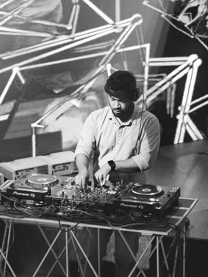 A wider black and white view of my DJ setup, including the speakers. This shows the complete professional rig I use to deliver powerful and clear sound for any event.