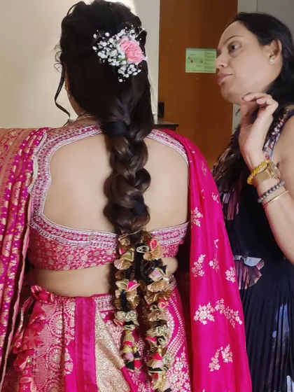 My client Gunjan ready for a wedding event in a stunning pink Gujarati lehenga, with a paranda-adorned braid.