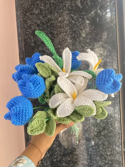 Holding the ocean blue bouquet by a window, the natural light brings out the beautiful textures of the crochet work.