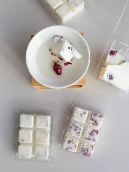 Our white wax melts with dried rosebuds, shown here melting in a ceramic diffuser.