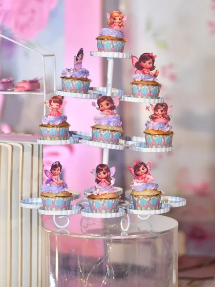 Themed desserts are a must. Here are some fairy-topped cupcakes displayed on a multi-tiered stand.