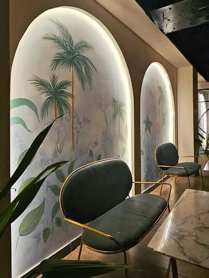 The hand-painted tropical murals inside "Don't Tell Mama." These art pieces, framed by soft, backlit arches, are a key feature that adds a unique, artistic touch to the restobar's ambiance.