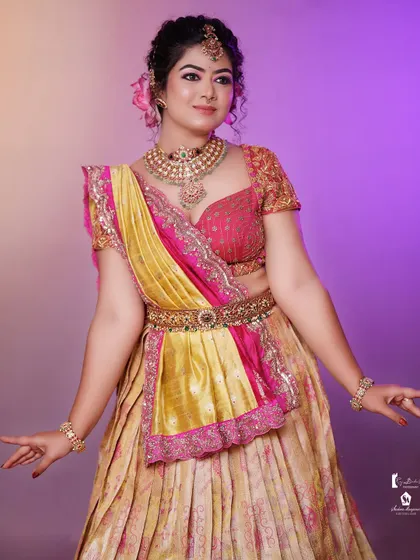 This full look shows how the hairstyle complements the half-saree and modern jewelry.