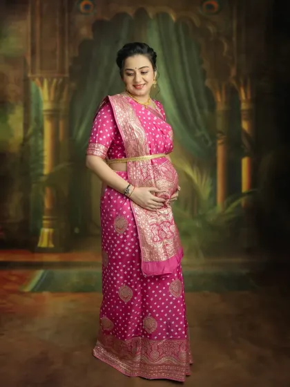 A classic solo maternity pose in a stunning pink saree. This portrait focuses on you and your beautiful bump, creating a simple yet powerful image of motherhood.