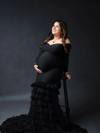 A joyful and radiant portrait of an expectant mother. A simple stool is a great prop in the studio to create elegant seated poses.