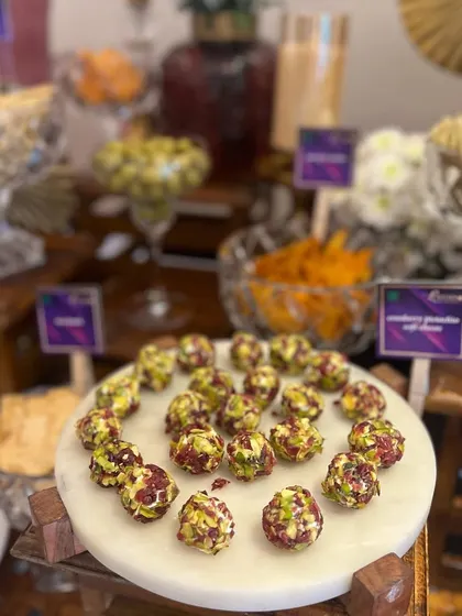 A beautiful marble platter featuring our pistachio and cranberry cheese truffles, a popular choice for cocktail hours and grazing tables.
