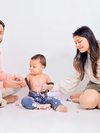 Parents joining in on the fun. A cake smash session is a memorable experience for the entire family, and I make sure to capture these interactive moments.