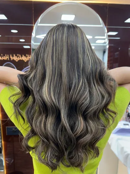 The back view of this ash blonde style, showing how the highlights are woven through the hair for a natural yet impactful look.