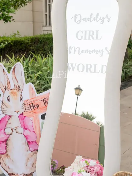 A close-up of the whimsical mirror and a Peter Rabbit-style cutout, adding to the garden party feel.