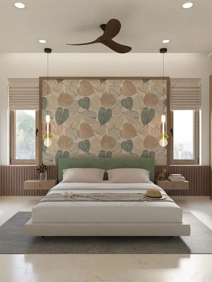 This bedroom design is light, airy, and connected to nature. The leaf-patterned wallpaper behind the bed serves as a beautiful focal point, complemented by hanging pendant lights and light wood furniture.