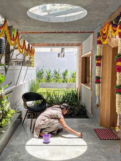 A moment captured during a housewarming ceremony, as a woman creates a rangoli within a perfect circle of sunlight from a skylight above. This is exactly why we design with light, to create spaces for life's simple rituals.