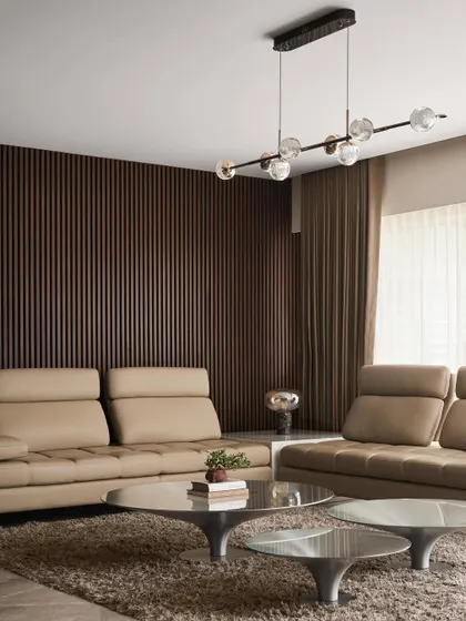 A detail of the living room, showing the contrast between the dark fluted wood accent wall and the soft beige leather sofas. A modern glass bubble chandelier adds a touch of sculptural elegance.