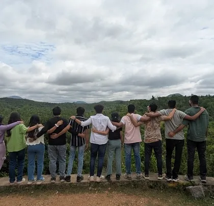 A group of friends enjoying the view from the back, arms around each other. My trips are about building bonds and making connections.