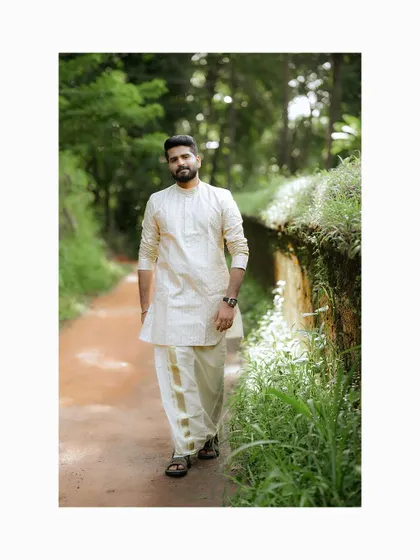 A stylish portrait of the groom walking in his traditional attire.