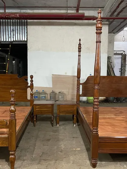 Two different styles of colonial beds side-by-side in my workshop. One is a four-poster design, and the other features a shorter post design, both with matching nightstands.
