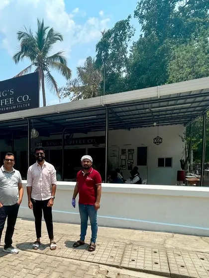 The Sparkleminds team stands with the founders outside a modern King's Coffee Co. outlet. This demonstrates the brand's evolution and our role in preparing them for the next stage of growth.