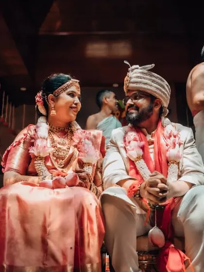 A candid moment between a bride and groom during their wedding ceremony, sharing a private smile that speaks volumes.