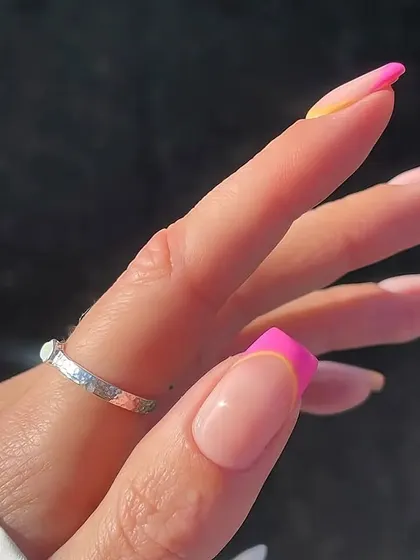 A side view of the pink and yellow abstract French manicure, showing the clean application and vibrant colors that make this design so eye-catching.