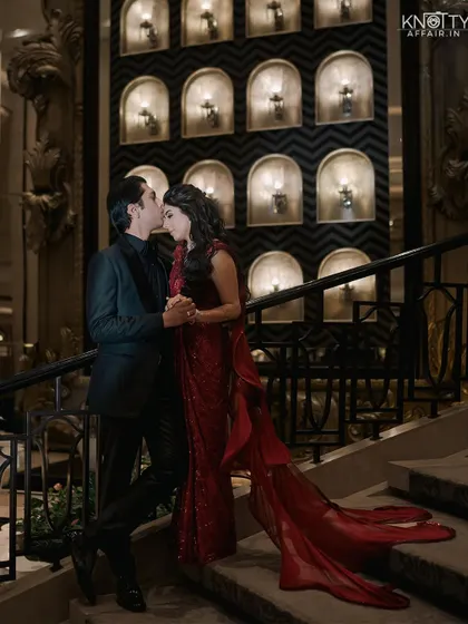 A romantic portrait on a grand staircase, with the groom kissing the bride's forehead. We use architectural elements to create a sense of grandeur.
