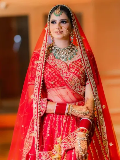 A classic bridal portrait in a red lehenga, capturing her elegance and poise.