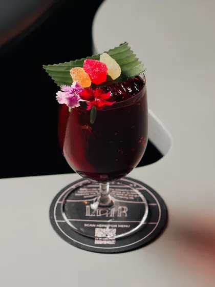 We turned a strawberry salad recipe into a cocktail called 'Not A Berry'. It features gin, balsamic, rhubarb, and a flat sparkling wine for a sweet, tangy, and unexpected flavor profile.