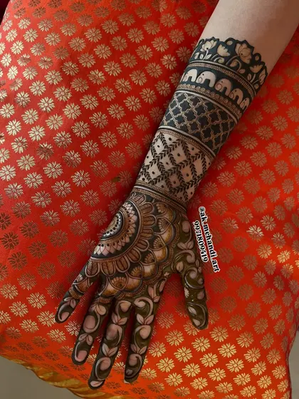 This bridal design features a band of elephants on the forearm, a symbol of good luck and prosperity.