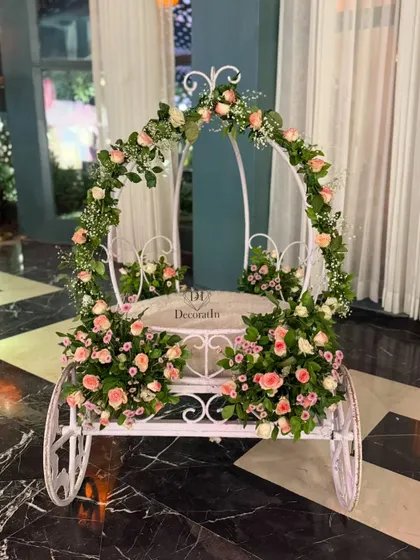 A fairytale entrance for a little princess. This beautiful white carriage, adorned with fresh pink and white roses, served as a stunning photo prop and seating for the birthday girl.