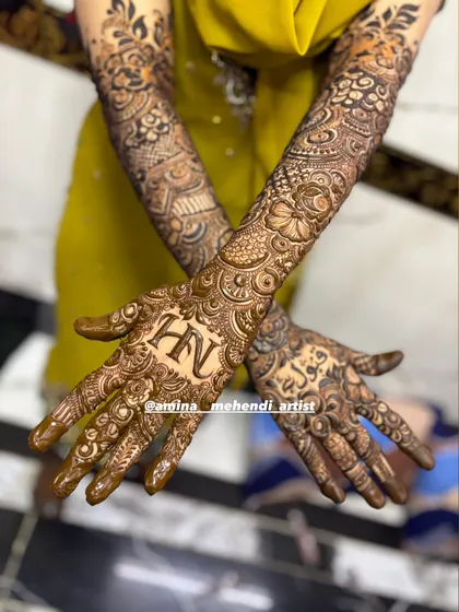 This design features the initials 'H' and 'N' on one palm and the name 'Fawad' in Arabic on the other.