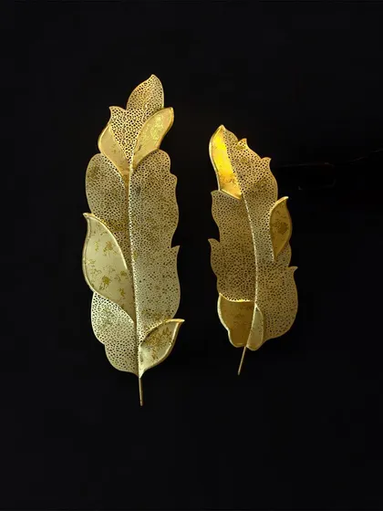 A simple yet elegant set of two golden metal leaves with a perforated texture. These look beautiful against a dark background, highlighting their delicate design.