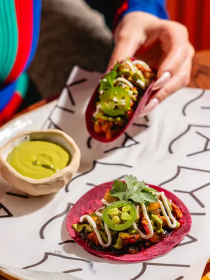 Colorful mini tacos at Lyla Bombay. The vibrant purple of the taco shells and the fresh toppings make for a visually appealing and shareable dish.
