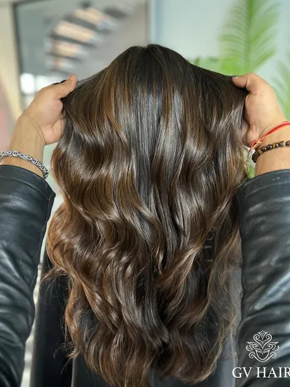 Shaping hair, shaping confidence. This glossy, dark brown with soft waves is pure elegance.