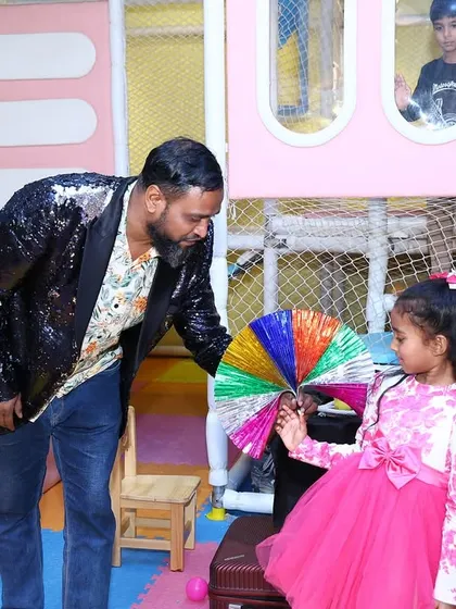 A magician performs a colorful trick for the birthday girl at her Peppa Pig party, adding an extra layer of fun and wonder to the day.