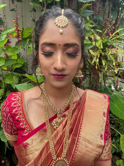 A detailed shot of the eye makeup for this traditional look. The blend of deep red and shimmer creates a dramatic effect that is perfect for festive occasions.