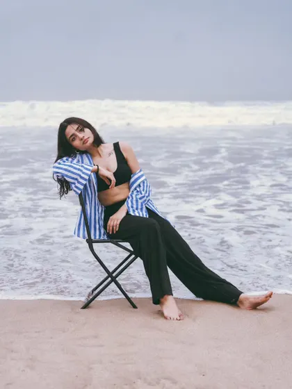 A relaxed, full-body pose on the chair, with the waves at her feet. This creates a story and a very editorial feel.