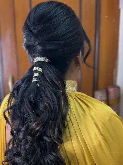 Another angle of the accessorized ponytail, showing how the light catches the rhinestones and the curls.