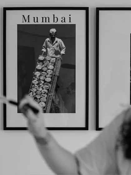 A creative shot of the bride getting her makeup done, framed by posters of Mumbai. It connects her personal moment to the larger story of her city.