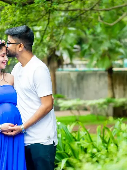 A gentle forehead kiss is a simple yet powerful gesture of love. This shot captures the tenderness between the couple during their outdoor maternity session, with the mom-to-be in a beautiful blue gown.
