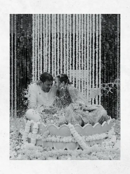 A black and white shot of the couple during their Haldi, captured in a moment of laughter and joy. The monochrome adds a timeless feel to the festive chaos.