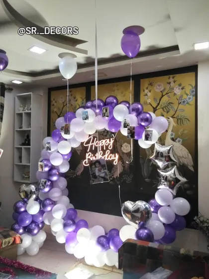 A personalized 18th birthday surprise, featuring a purple and white balloon ring decorated with memorable photos of the birthday girl.