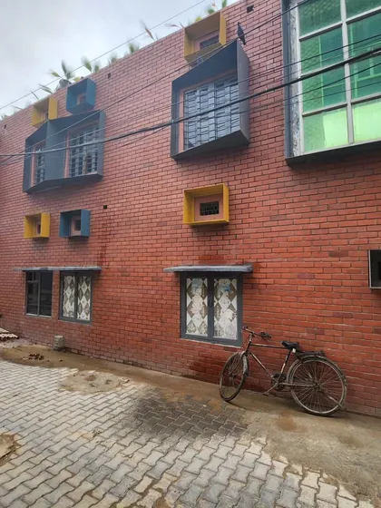 The exterior facade of the school, where we introduced playful, colorful window boxes in various shapes and sizes. This adds a sense of fun and individuality to the building while maintaining the earthy brick aesthetic.