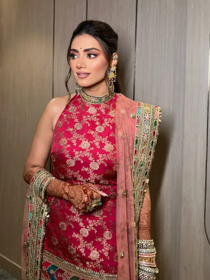 A full view of Tanvi's mehendi look. The pink eye makeup adds a touch of playfulness to the traditional outfit.
