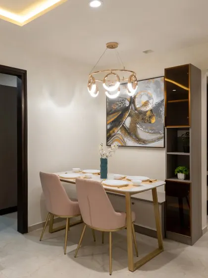 The dining area in our NESTA range, featuring a sleek table, comfortable chairs, and a modern chandelier. A glass-front crockery unit provides stylish storage.