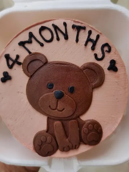 A 4-month celebration bento cake with a sweet teddy bear made from fondant.